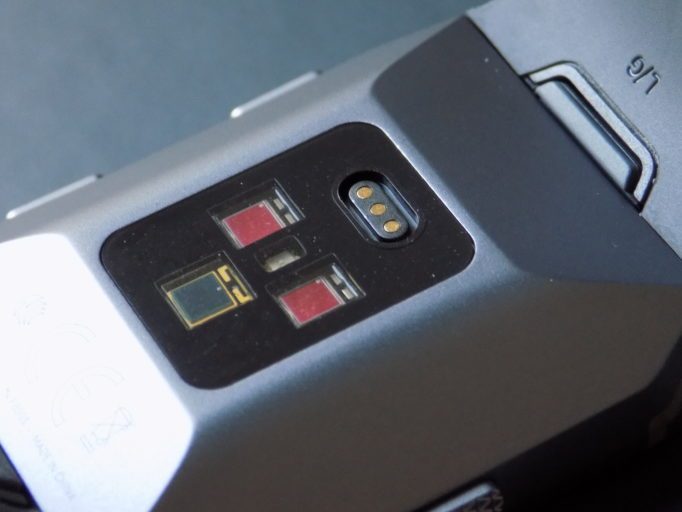 Around the back are three optical sensors and a magnetic charging port 