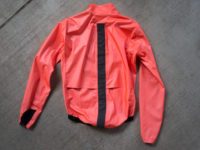 back view of the Assos ÉQUIPE RS jacket laying on cement