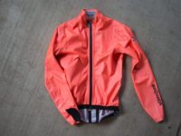 Assos ÉQUIPE RS in orange laying on cement