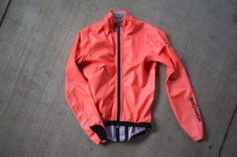Assos ÉQUIPE RS in orange laying on cement