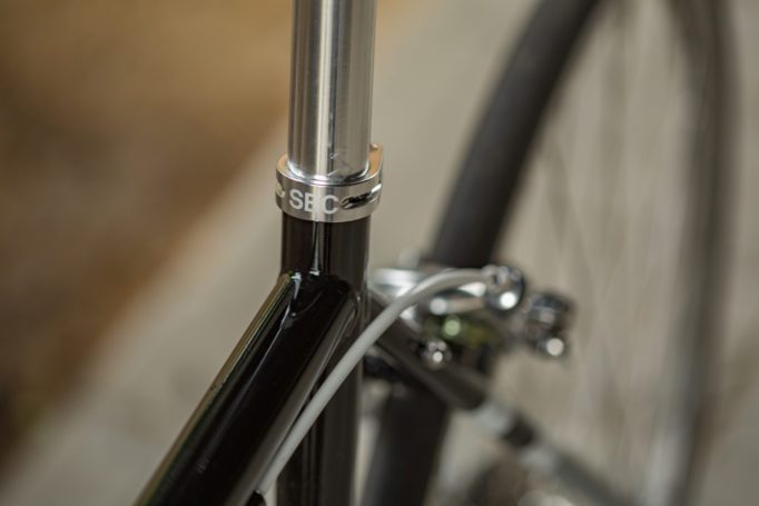 angled view of the rear triangle and rear brakes on a road bike with an out of focus background.